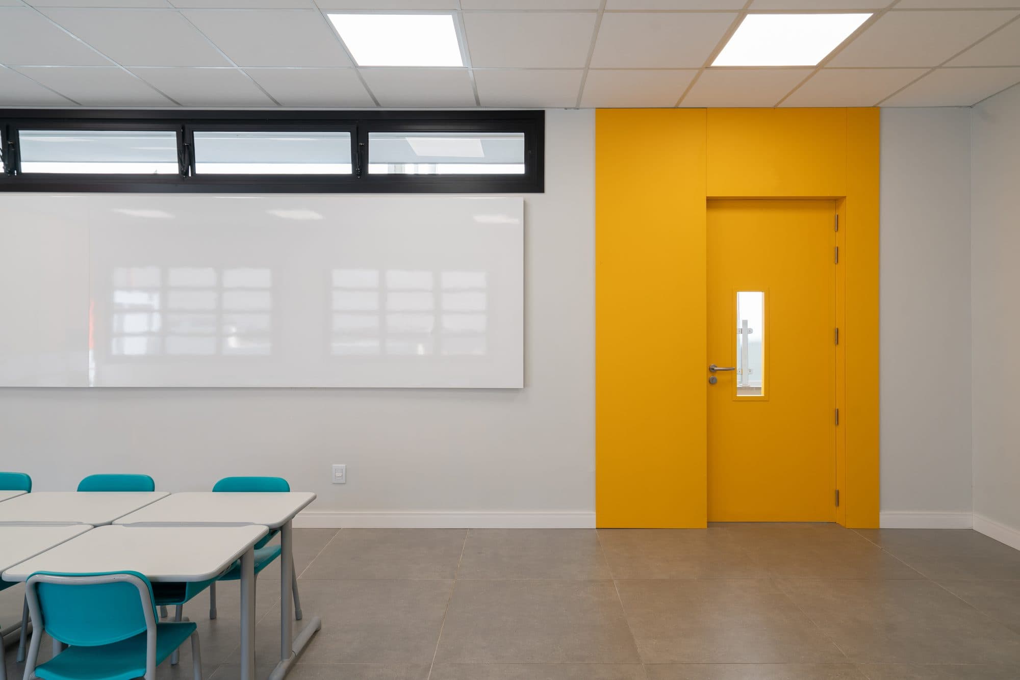 Sala de aula com porta amarela em revestimento PET