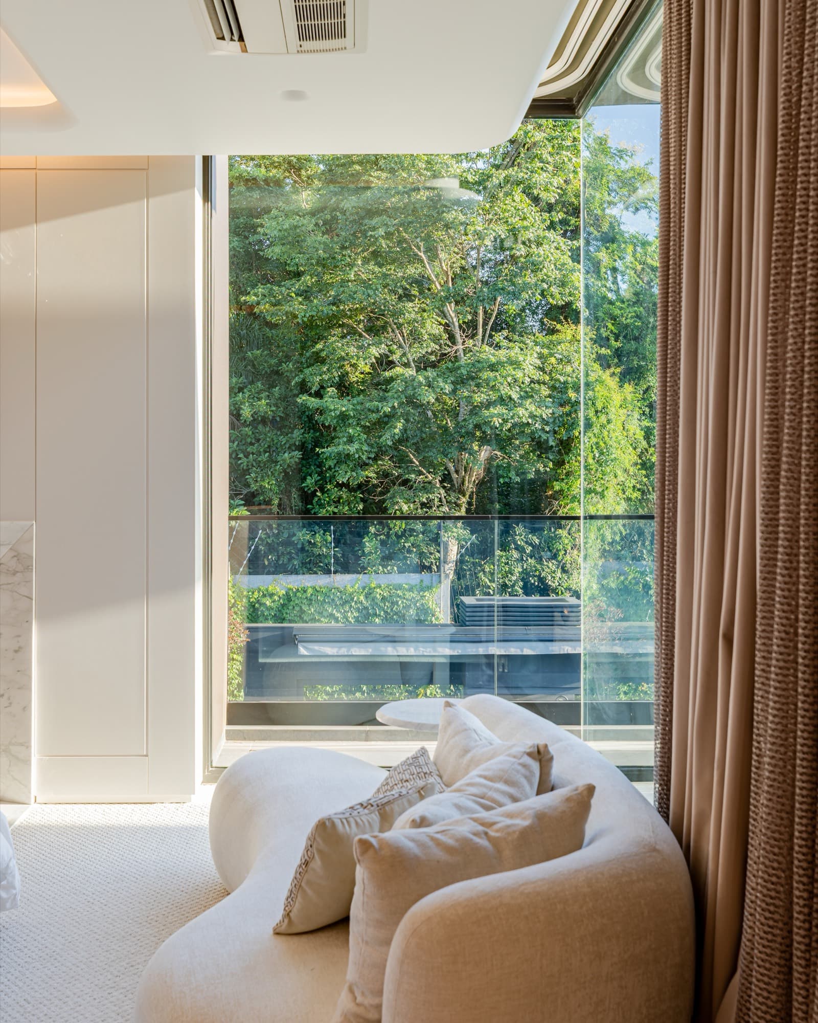 Estar íntimo com esquadria de vidro até o teto e cortina